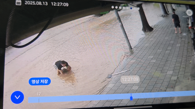 기록적인 폭우가 쏟아진 인천 지역에서 물난리를 막기 위해 맨홀 뚜껑을 직접 들어올린 30대 남성 김동희씨가 화제가 됐다. 영상은 김씨가 맨홀 뚜껑을 들어 올리는 모습. /영상=뉴스1
