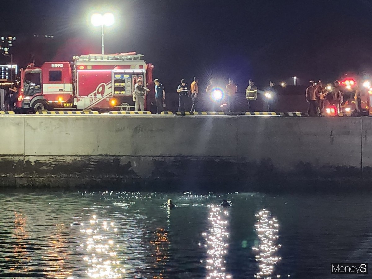 여수해경 관계자들이 해상으로 추락한 승용차를 인양하고 있다/사진=여수해경 제공.