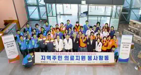 쌍용C&amp;E가 지난 1일 동해공장 의료봉사 현장에서 기념촬영을 하는 모습. /사진=쌍용C&amp;E