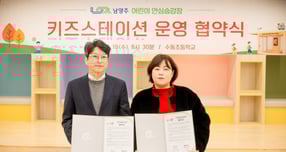  홍지선 남양주시 부시장(왼쪽)이 19일 수동초등학교에서 곽유선 수동초 학부모회장과 어린이 안심승강장 &#039;키즈스테이션&#039; 운영 협약 체결하고 협약서를 들고 사진촬영을 하고 있다. /사진제공=남양주시 