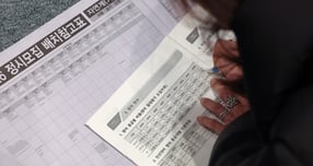 지난 7일 서울 종로구 성균관대학교 600주년 기념관 천년홀에서 열린 종로학원 2026 정시 합격 가능선 예측 및 지원전략 설명회를 찾은 한 학부모가 바닥에 앉아 입시 자료를 보며 설명을 듣고 있다. /사진=뉴스