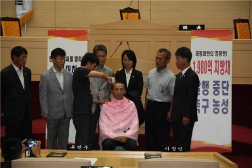 9일 오전 전남도의회 본회의장에서 이정민 통합진보당 전남도의원이 F1대회 중단을 요촉구하며 삭발을 하고 있다. 