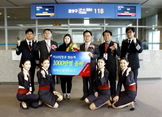 ▲20일 오전 인천국제공항에서 열린 이스타항공 누적 탑승객 1000만명 돌파 행사에서 박수전 이스타항공 대표이사(뒷열 우측에서 세 번째), 최종구 부사장(뒷 열 좌측에서 두 번째) 및 승무원들이 1000만번째 탑승고객인 임연진씨(뒷열 좌측에서 세 번째)와 기념촬영을 하고 있다.
