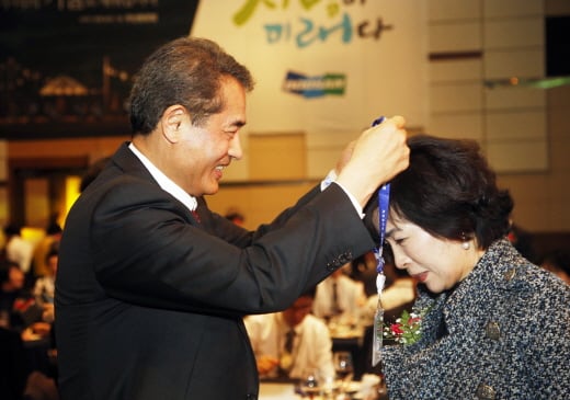 ▲지난 21일 창원 컨벤션센터에서 열린 두산중공업 2013 신입사원 패밀리 데이 행사에서 두산중공업 한기선 사장(왼쪽)이 신입사원 부모들에게 명예사원증을 수여하고 있다.