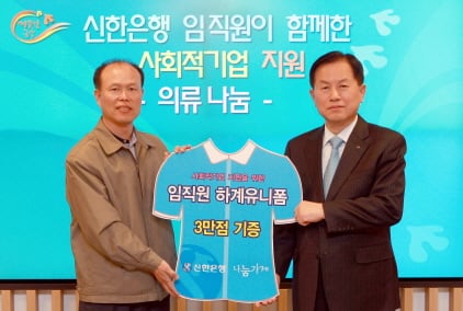 ▲신한은행 서진원 은행장이(오른쪽) 나눔가게 이경수 대표(왼쪽)에게 임직원 하계유니폼 3만점을 자원 재활용과 사회적기업을 돕는 나눔문화 운동 확산 하자는 취지로 기증한 후 기념촬영하고 있다.