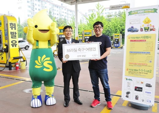 구도일 패밀리 고객 사은행사의 브라질 축구 응원 여행권 당첨자 이상영씨(오른쪽)가 지난 2일 경기도 시흥시 정왕동 시흥버스터미널 주유소에서 S-OIL 관계자로부터 브라질 축구 응원 여행권을 전달받고 기념촬영을 하고 있다. /사진제공=S-OIL