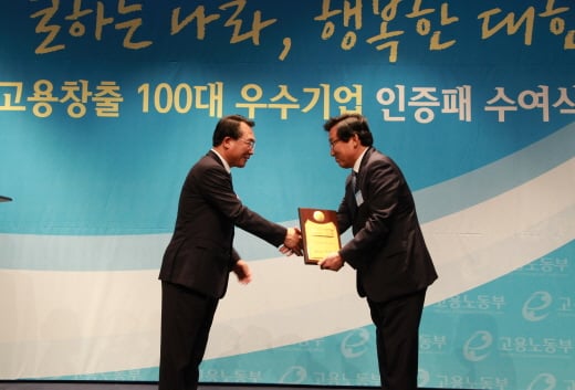 ▲ 스타벅스커피 코리아 이석구 대표이사(우측)가 방하남 고용노동부 장관(좌측)으로부터 고용창출 우수기업 대통령 표창을 2년 연속 수상하고 있다. (제공=스타벅스)