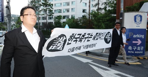 다음 카페 ‘너땜에졌어’ 회원들이 지난 4일 오후 서울 종로구 신문로 축구회관 앞에서 ‘한국축구는 죽었다’라고 적힌 플래카드를 든 채 홍명보 감독 유임결정에 항의하기 위해 협회로 걸음을 옮기고 있다. /사진제공=뉴스1 민경석 기자