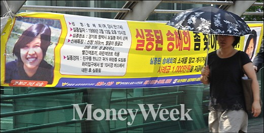 18세 때 실종된 송혜희양을 찾는 현수막 앞으로 한 시민이 걸어가고 있다.