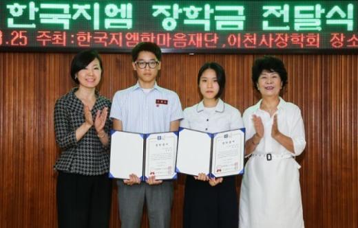 황지나 한국지엠 홍보부문 부사장(왼쪽)과 이현숙 이천사 장학회 회장(왼쪽에서 네번째)이 장학금을 전달받은 두 학생과 포즈를 취하고 있다.(사진제공=한국지엠)