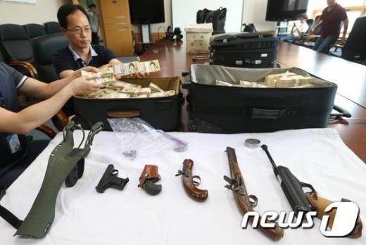 인천지검 특별수사팀이 지난달 12일 인천 남구 인천지검에서 유병언 전 세모그룹 회장의 도피를 도운 혐의를 받고 있는 '김엄마' 김명숙(59·여)씨의 친척집에서 발견한 권총 5자루와 15억원에 달하는 현금을 공개하고 있다. /사진제공=뉴스1
