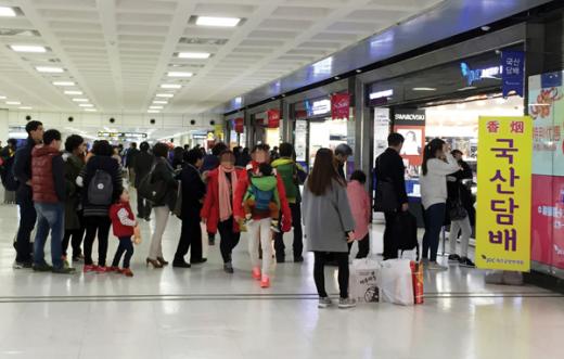 담뱃값이 4000원대로 인상되면서 가격이 오르지 않은 면세담배를 구입하려는 여행객들이 제주공항 면세점 담배코너에 줄지어 서 있다. /사진=뉴시스 조성봉 기자