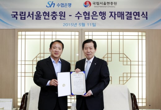 이원태 수협은행장(오른쪽)이 11일 서울 동작구에 소재한 국립서울현충원에서 이선근 원장과 자매결연 협약을 맺고 기념촬영을 하고 있다. /사진제공=수협은행