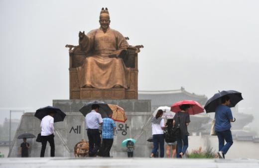 서울 광화문 광장에서 시민들이 우산을 쓴 채 발걸음을 재촉하고 있다/사진=뉴스1