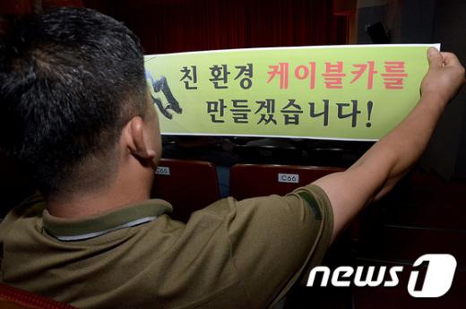 1일 양양문화복지회관에서 열린 친환경케이블카 설치를 위한 범군민 결의대회에 한 군민이 친환경 케이블카 건설을 다짐하는 슬로건이 담긴 띠를 꼭 쥐고 있다. /사진=뉴스1