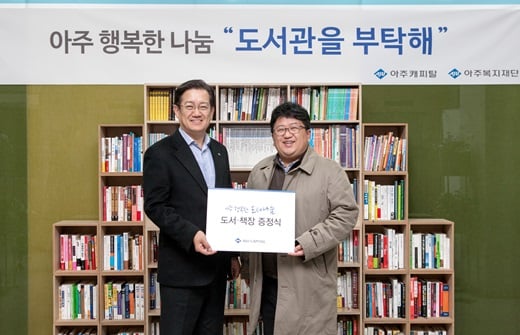 16일 서울 서초구에 위치한 아주캐피탈 본사 로비에서 아주캐피탈 이윤종 사장(왼쪽)이 비전학교 아동센터 최선열 대표에게 임직원이 기부한 도서를 전달하고 있다. /사진=아주캐피탈