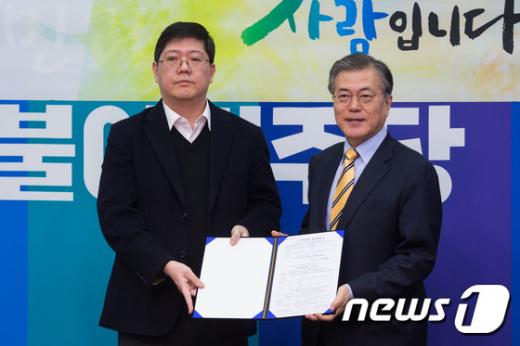 고 김대중 전 대통령의 3남 김홍걸 연세대 김대중도서관 객원교수(왼쪽)가 지난 24일 서울 여의도 국회에서 더불어민주당 입당 기자회견을 마친 후 문재인 대표에게 입당원서를 전달하고 있다. /사진=뉴스1