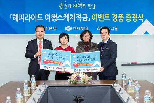 광주은행 송종욱 부행장(왼쪽)과 (주)하나투어 정일보 이사(오른쪽)가 해피라이프 여행스케치 적금 이벤트 1등 당첨 고객에게 해외여행상품권을 전달한 뒤 기념촬영을 하고 있다.