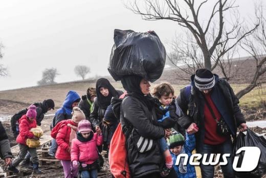 이주자들과 난민들이 지난 27일(현지시간) 마케도니아 국경을 통해 세르비아로 들어간 뒤 미라토바츠 인근 지역을 지나고 있다. /사진=뉴스1(AFP 제공)
