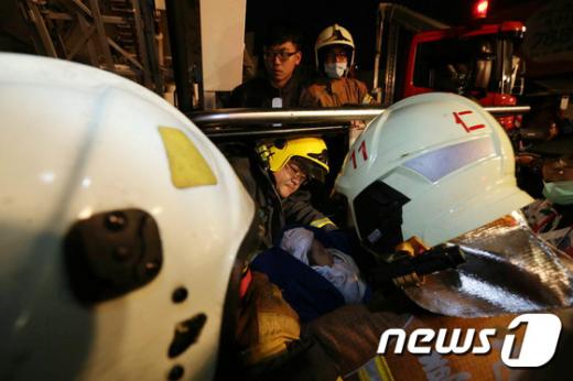대만 소방대원들이 6일 규모 6.4의 지진이 발생한 남부 타이난시 피해 현장에서 아기를 구조하고 있다. /사진=뉴스1 국종환 기자