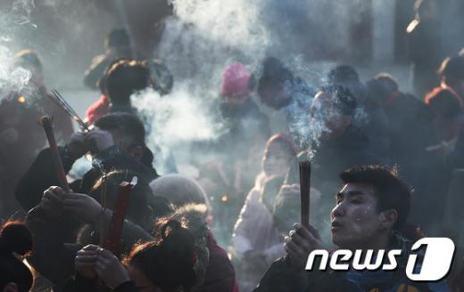 한 남성이 지난 8일 중국 베이징 융허궁에서 향을 피우며 소원을 빌고 있다. /사진=뉴스1(AFP 제공)