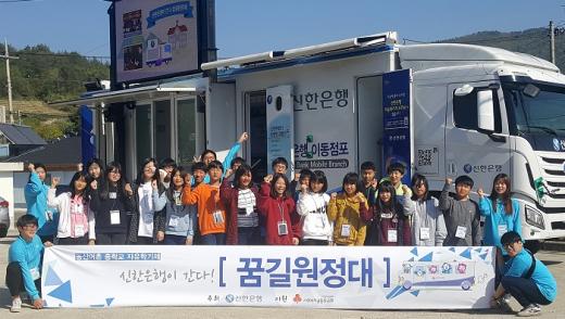  전라남도 고흥군 소재 금산중학교에서 중학교 자유학기제 전면시행에 발맞춰 진행한 신한은행의 찾아가는 금융체험교실 ‘신한은행이 간다! 꿈길원정대’ 프로그램을 마치고 금산중학교 학생들이 이동점포 ‘뱅버드’ 앞에서 기념촬영하는 모습./사진=신한은행