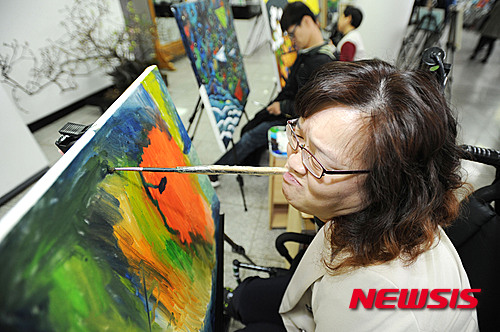 제35회 장애인의 날을 맞아 지난해 4월 서울 송파구 구민회관에서 개최한 '2015 송파 장애인의 날' 행사에서 이현정 화가가 입으로 붓을 물고 그림을 그리고 있다. /자료사진=뉴시스