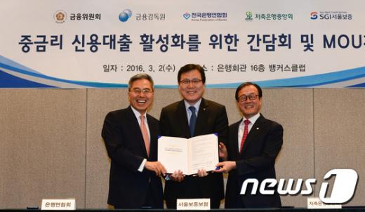 하영구 은행연합회장, 최종구 SGI서울보증사장, 이순우 저축은행중앙회장(왼쪽부터)이 지난 3월 초 서울 명동 은행회관에서 열린 '중금리 신용대출 활성화를 위한 MOU 체결식'에서 양해각서를 들고 기념촬영을 하고 있다. /자료사진=뉴스1