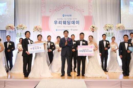 3일 서울 중구 소공로 소재 우리은행 본점에서 열린 ‘우리다문화장학재단, 제5회 우리웨딩데이’에서 이광구 우리은행장(가운데)의 주례로 7개국의 다문화가족 10쌍을 대상으로 결혼식을 실시한 뒤 다함께 기념촬영하고 있다./사진=우리은행