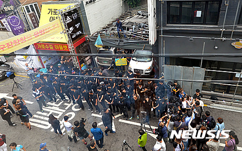 리쌍 건물에서 세입자 퇴거 강제집행이 진행되고 있는 가운데 시민단체 '맘상모' 회원들이 퇴거에 동원된 용역직원들을 막아서고 있다. /사진=뉴시스