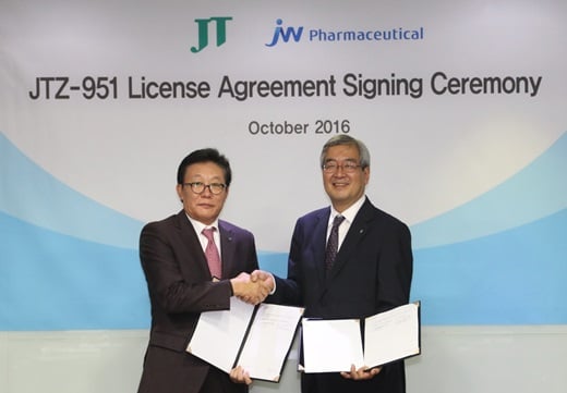 한성권 JW중외제약 대표(왼쪽)와 후지모토 무네아키 일본 타바코 의약사업부장이 17일 신성 빈혈치료제 ‘JTZ-951’에 대한 라이선스계약 체결 후 기념사진을 촬영하고 있다. /사진=JW중외제약