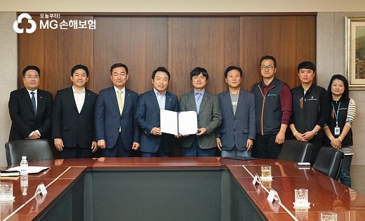 (사진 중앙)합의서를 들고 있는 김동주 MG손보 대표이사, 김현정 전국사무금융서비스노동조합 위원장. (오른쪽에서 세 번째) 이문수 MG손해보험지부 위원장. /사진=MG손해보험