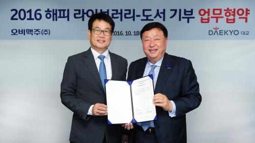 ▲ 지난 18일 서울 강남 오비맥주 본사에서 오비맥주 정책홍보담당 장유택 전무(왼쪽)와 대교 사회공헌실 서명원 실장이 ‘2016 해피 라이브러리-도서 기부’ 업무협약(MOU)을 체결한 후 기념촬영을 하고 있다.(제공=오비맥주) @머니S MNB, 식품 유통 · 프랜차이즈 외식 & 창업의 모든 것