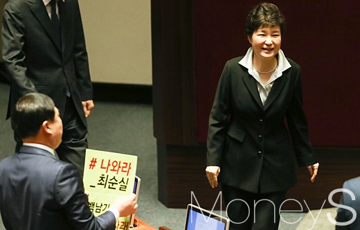 최순실 사건 정리. 박근혜 하야. 김종훈 무소속 국회의원(왼쪽 등 보이는 이)이 지난 24일 국회에서 시정연설을 마친 뒤 내려오는 박근혜 대통령을 향해 '나와라 최순실' 등이 적힌 항의 피켓을 들어보이고 있다. /자료사진=임한별 기자