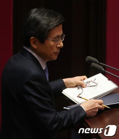 이재정 의원. 황교안 국무총리가 오늘(11일) 국회에서 열린 대정부 긴급현안질문에서 이재정 민주당 의원이 전달한 문체부 달력, 오방색 끈을 들고 이동하고 있다. /사진=뉴스1