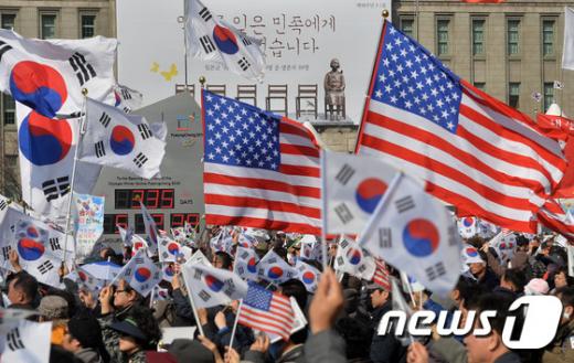 11일 오후 서울 덕수궁 대한문 일대에서 탄핵무효국민총궐기운동본부 주최로 열린 태태극기 집회에서 참가자들이 태극기와 성조기를 흔들고 있다. /사진=뉴스1