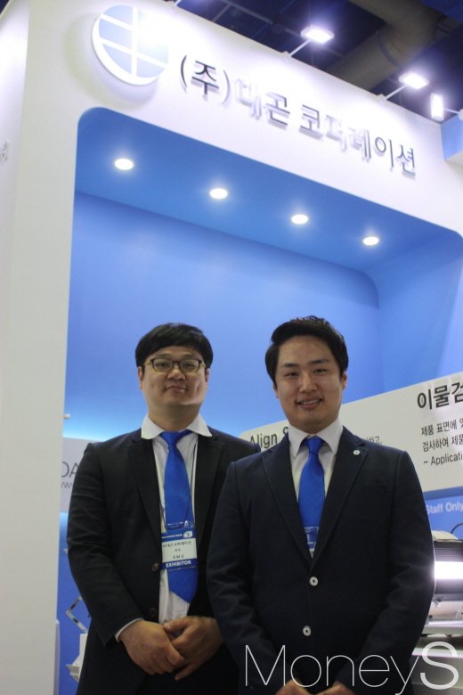 표면검사기 앞에 선 대곤코퍼레이션 관계자들. /사진=김수종 에디터