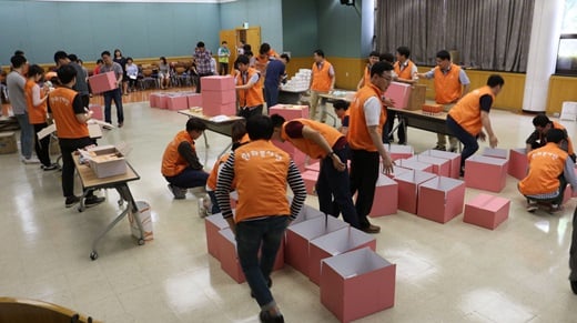 한화시스템 직원들이 지난달 31일 구미사업장에서 초록우산어린이재단과 함께 지역 여성청소년에게 제공할 여성용품을 담은 ‘사랑의 핑크박스’를 제작하고 있다. /사진=한화시스템