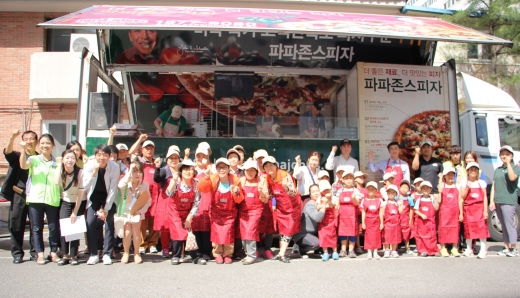 ▲ 한국파파존스 직원들과 우면동 지역 주민들이 2일 우면사회복지회관 앞에서 '맛있는 나눔 캠페인' 활동 진행하며 기념사진을 찍고 있다.