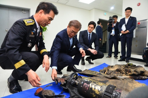 대통령 명령입니다. 문재인 대통령(왼쪽 2번째)이 7일 서울 용산소방서를 방문해 불에 탄 방화복과 방화장갑 등 소방장구를 살펴보고 있다. /사진=뉴시스