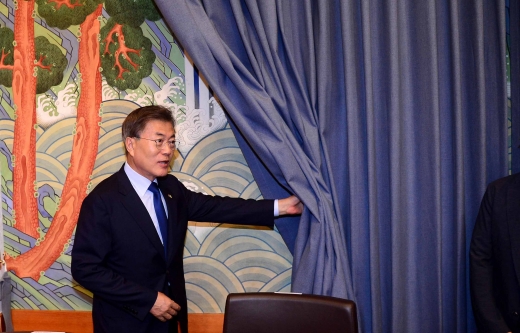 문재인 대통령이 21일 청와대에서 열린 일자리위원회 1차 회의 이전 그림을 덮고 있는 커튼을 걷어내고 있다. /사진=뉴시스