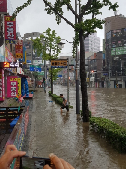 【인천=뉴시스】박진희 기자 = 수도권지방에 호우경보가 발령된 23일 오전 인천시 남구 간석동 도로가 집중호우 영향으로 침수되어 행인이 힘들게 걸어가고 있다. /사진=뉴시스, 더스토리짐 제공