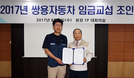 최종식 쌍용자동차 대표이사(오른쪽)와 홍봉석 노동조합위원장이 합의서에 서명한 뒤 기념촬영을 하고 있다. 