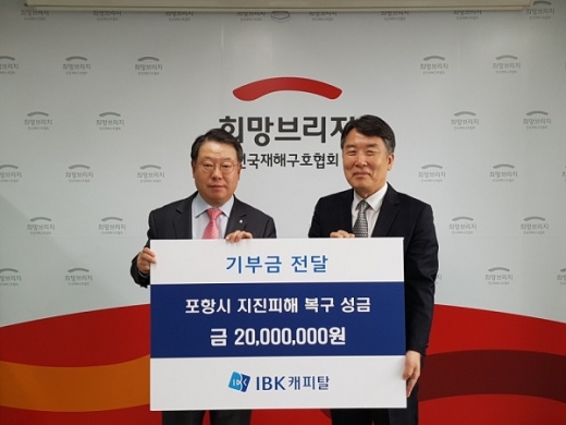 이상진 IBK캐피탈 대표(왼쪽)가 23일 박영진 전국재해구호협회 사무총장에게 포항 지진피해 복구성금 2000만원을 전달하고 있다. /사진=IBK캐피탈