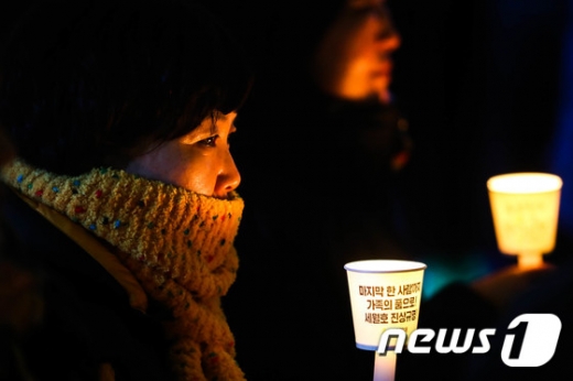 25일 오후 서울 광화문광장에서 열린 사회적참사 진상규명 특별법 입법 국민보고대회에서 한 세월호 유가족이 세월호 진상규명을 촉구하는 촛불을 들고 생각에 잠겨 있다./사진=뉴스1DB