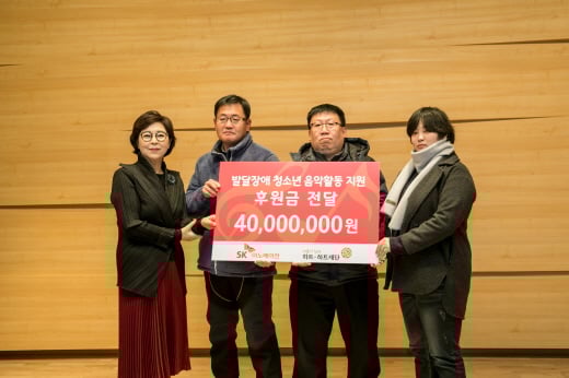 지난 8일 서울 송파구 소재 하트-하트재단 리사이틀홀에서 SK이노베이션 고객들이 하트-하트재단 신인숙 대표이사(왼쪽 첫번째)에게 발달장애 청소년 음악활동을 지원하기 위한 후원금을 전달하고 있다. / 사진=SK이노베이션