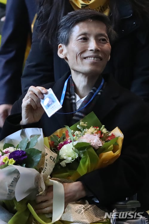 이용마 기자가 복직 출근길에 사원증을 받아들고 웃어보이고 있다. /사진=뉴시스