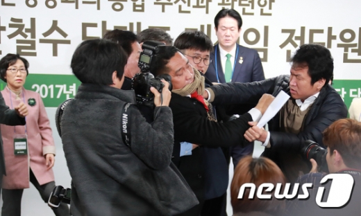 이동섭 국민의당 중앙당선거관리위원장이 31일 오전 서울 여의도 국민의당 당사에서 국민의당-바른정당의 통합을 추진하는 안철수 대표에 대한 재신임을 묻는 전(全)당원투표 결과를 발표 도중 반대파 당원으로 부터 강력한 항의를 받고 있다./사진=뉴스1DB
