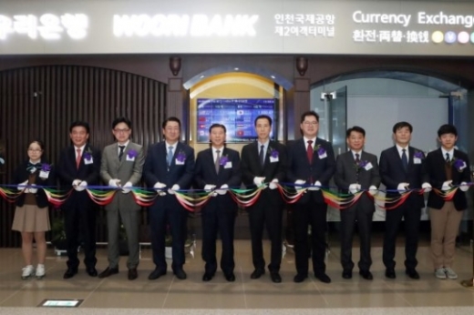 우리은행은 15일 오후 인천광역시 중구 운서동 인천국제공항 제2청사에서 ‘인천국제공항 제2여객터미널 영업점’ 개점식을 실시했다. 장안호 우리은행 국내부문장(왼쪽 다섯번째)이 안정준 인천국제공항공사 경영혁신본부장(왼쪽 일곱번째), 손홍기 인천출입국관리소장(왼쪽 여섯번째), 김종대 대한항공 전무(왼쪽 네번째) 등 주요 인사와 테이프 커팅을 하고 있다./사진=우리은행