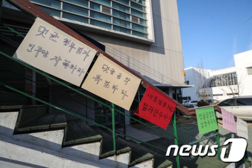 문재인정부를 비방하는 댓글을 올리고 추천 수를 조작한 혐의로 구속된 '드루킹' 김모씨가 공동대표로 있는 경기도 파주 느릅나무 출판사 출입 계단에 댓글 조작을 규탄하는 손팻말들이 걸려 있다./사진=뉴스1